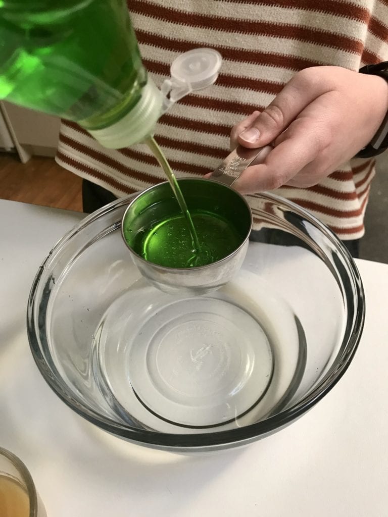 measuring dish soap using measuring cup
