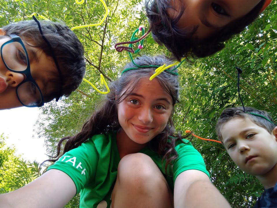 Summer camp chilrdren look into the camera with their counsellor.