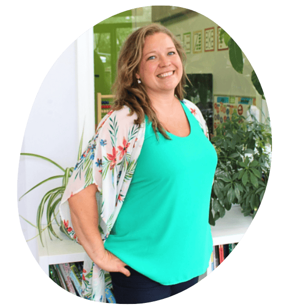 Portrait of the Principal of Oak Learners, wearing a green tank top and floral blouse, smiling at the camera.